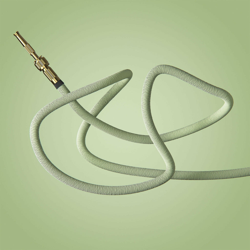 Fritz Tango Soft Expandable Garden Hose in green, beautifully coiled against a fresh green background. Showcasing its flexible, kink-free design and premium brass fittings, perfect for stylish gardening.